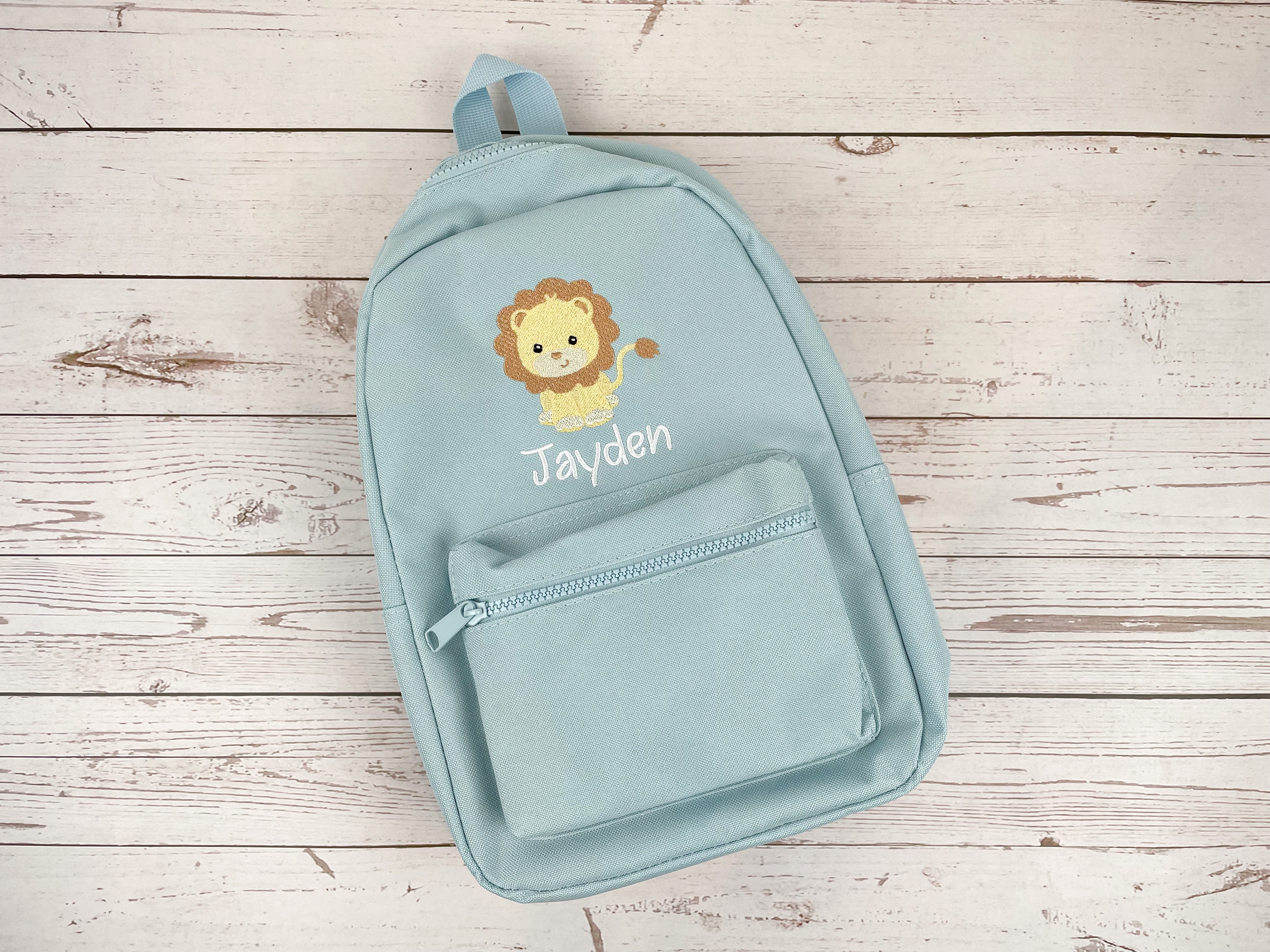 Kinderrucksack hellblau bestickt mit Löwe, personalisiert mit Name