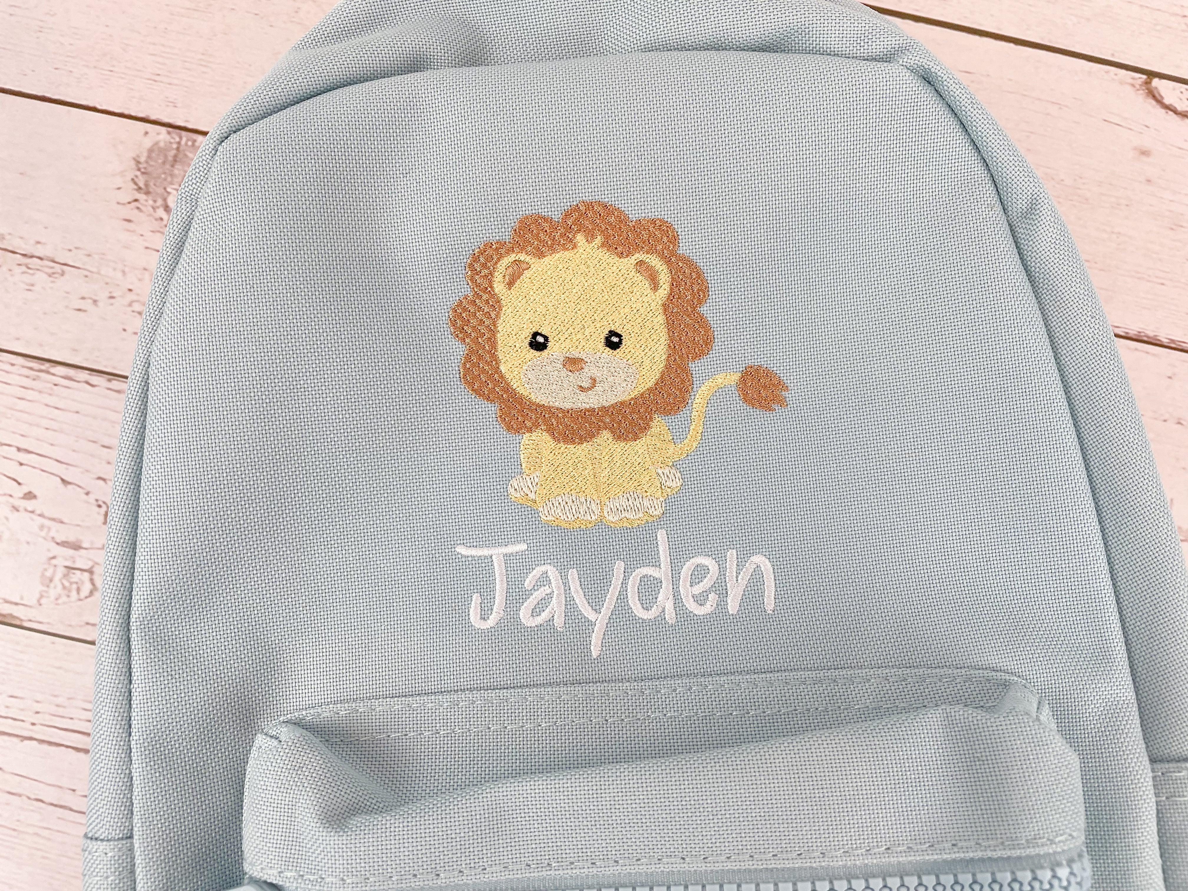 Kinderrucksack hellblau bestickt mit Löwe, personalisiert mit Name