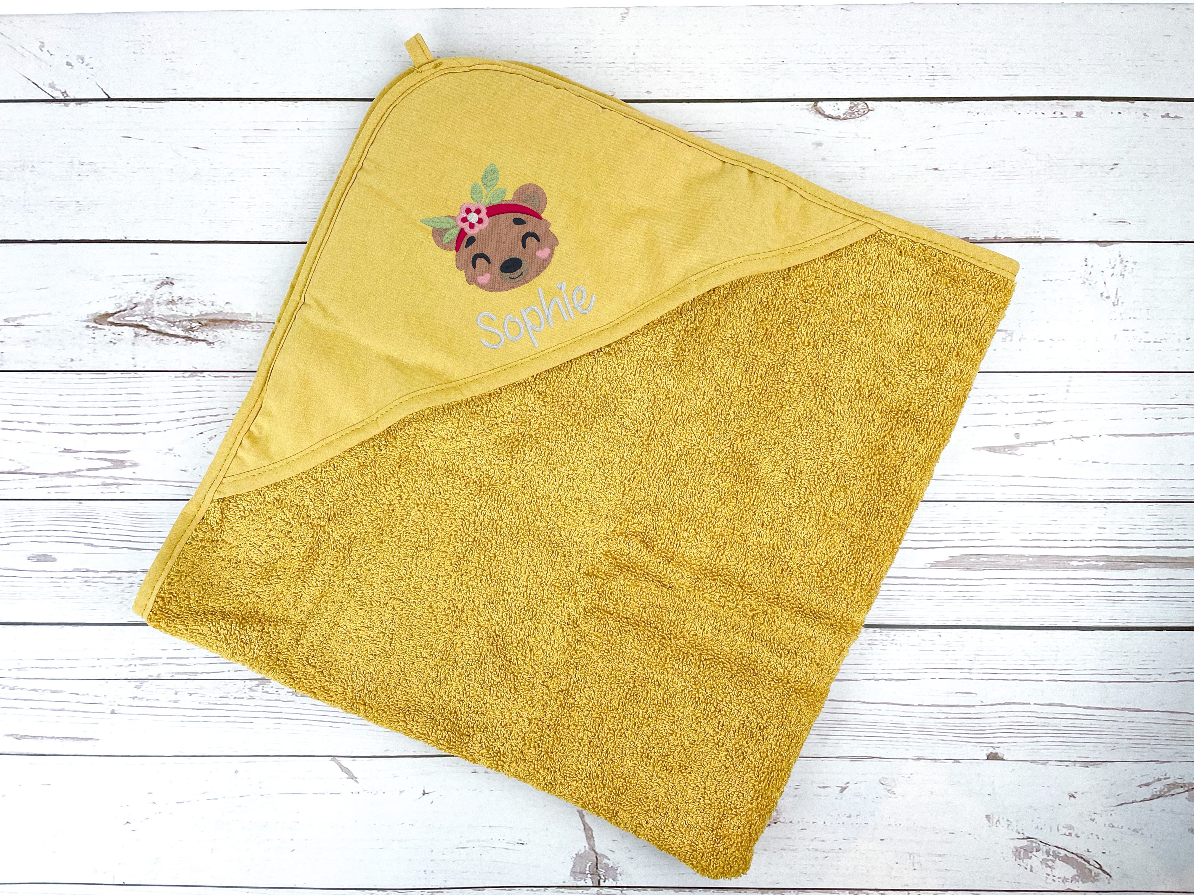Kapuzenhandtuch in senfgelb bestickt mit Bärenkopf und Blumenhaarband, personalisiert mit Name, 75 x 75 cm