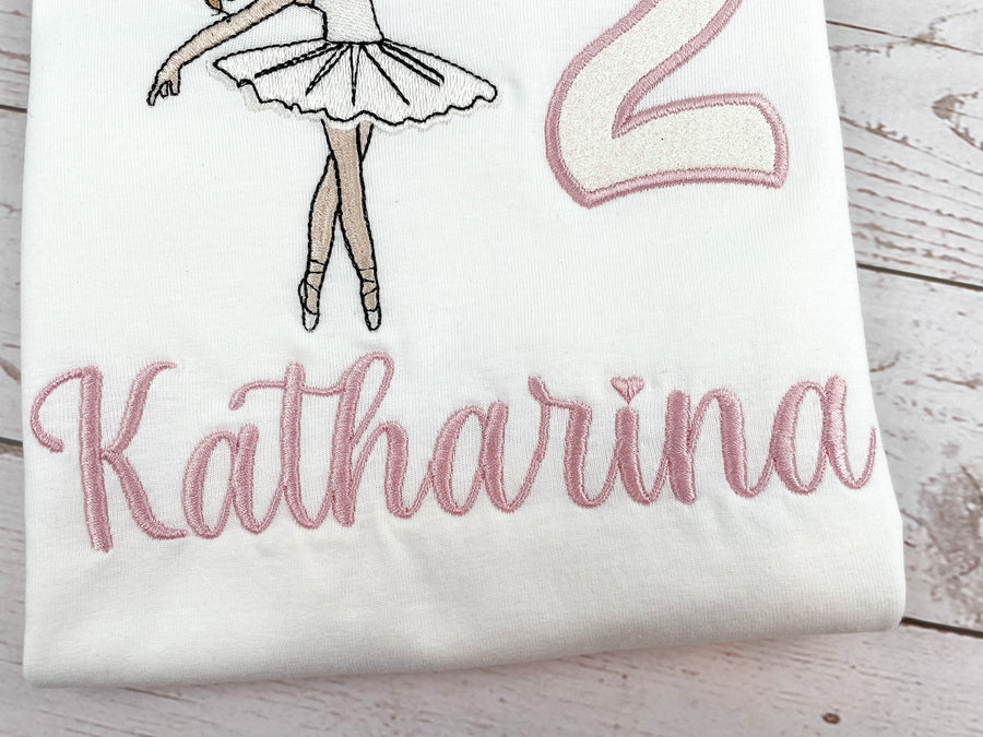 Produkte Geburtstagsshirt bestickt mit Ballerina und Zahl. Zahl mit Glitzerstoff unterlegt. Name in altrosa. 