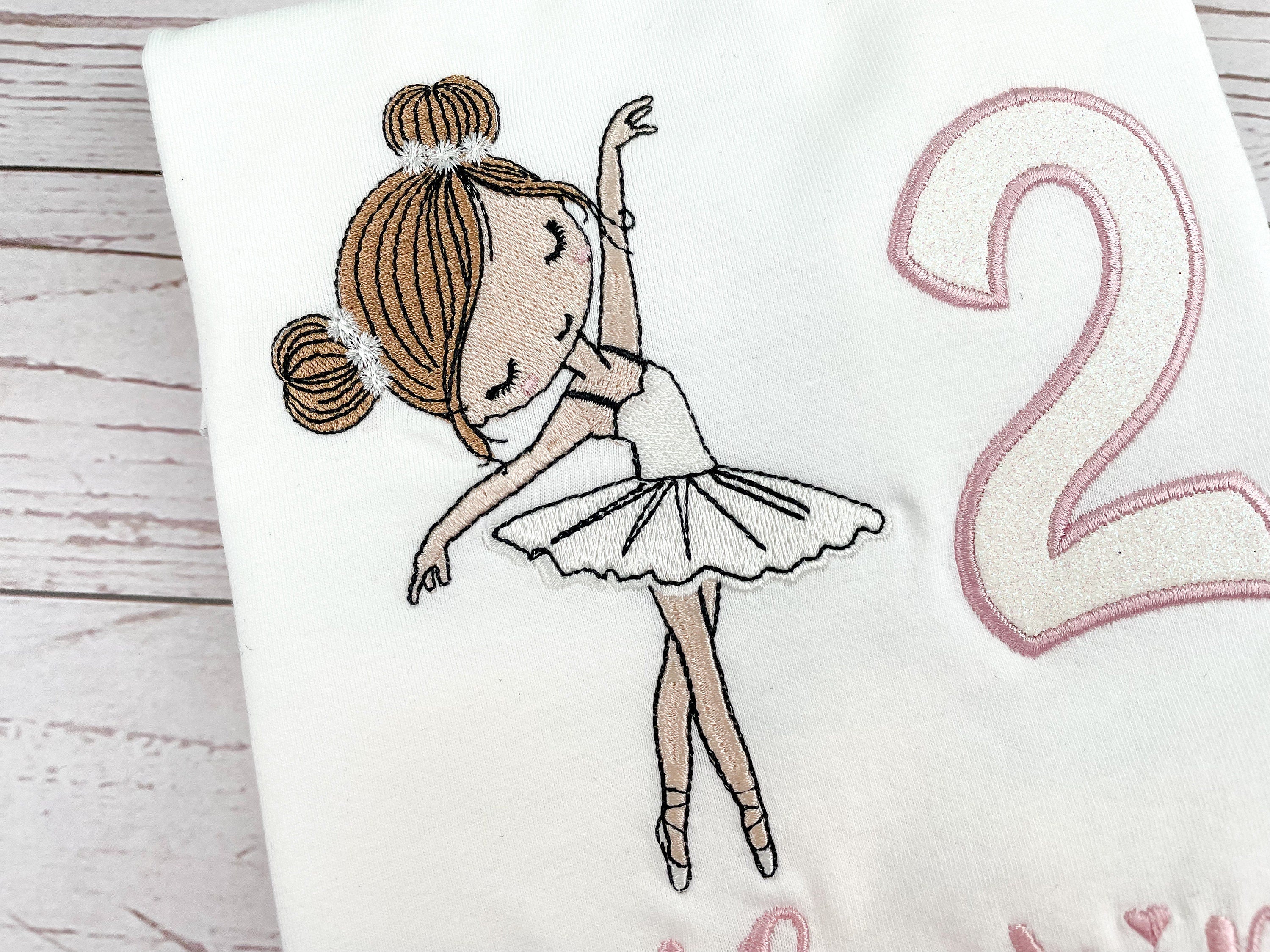 Produkte Geburtstagsshirt bestickt mit Ballerina und Zahl. Zahl mit Glitzerstoff unterlegt. Name in altrosa. 
